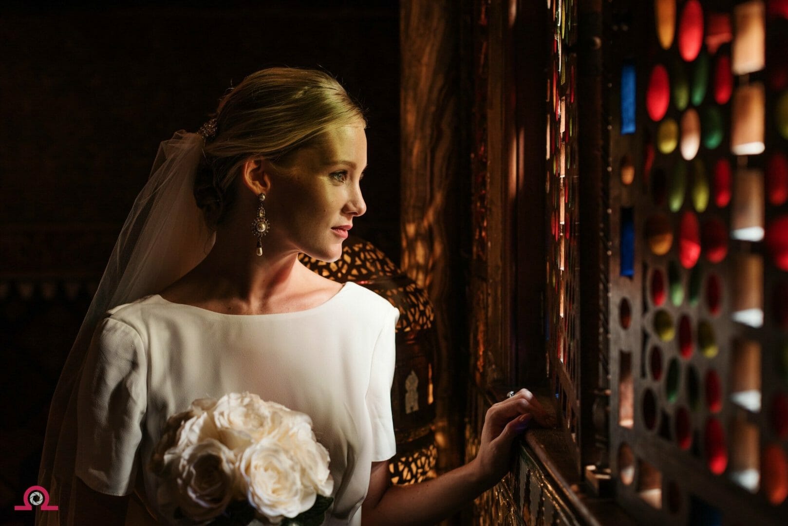 Bride looking out at the Stained glass in Rhinefield House the Alhambra room