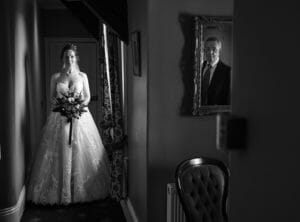 Black and White documentary wedding photograph of bride seeing father for the first time in her dress