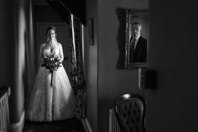 Black and White documentary wedding photograph of bride seeing father for the first time in her dress