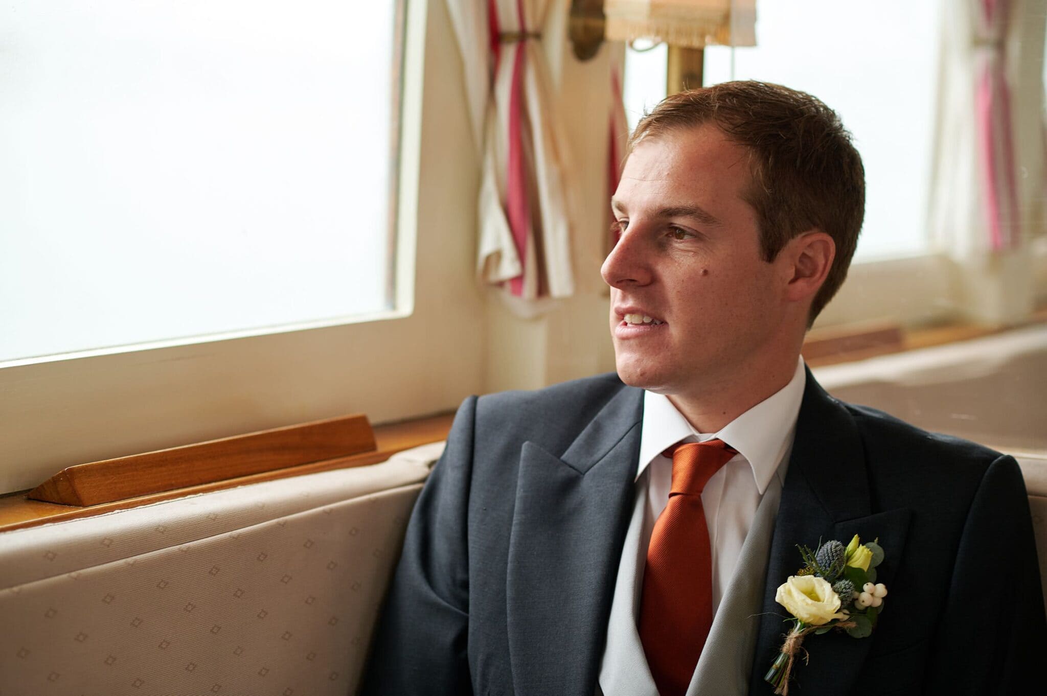 A thoughtful groom looks out at his Brownsea Island wedding