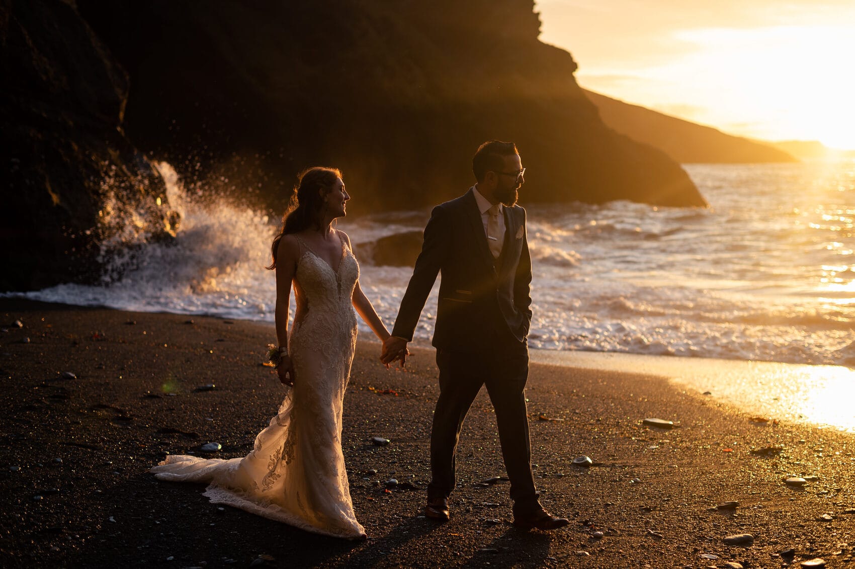 bride and groom walk the beech at Tunnels Beaches Wedding venue