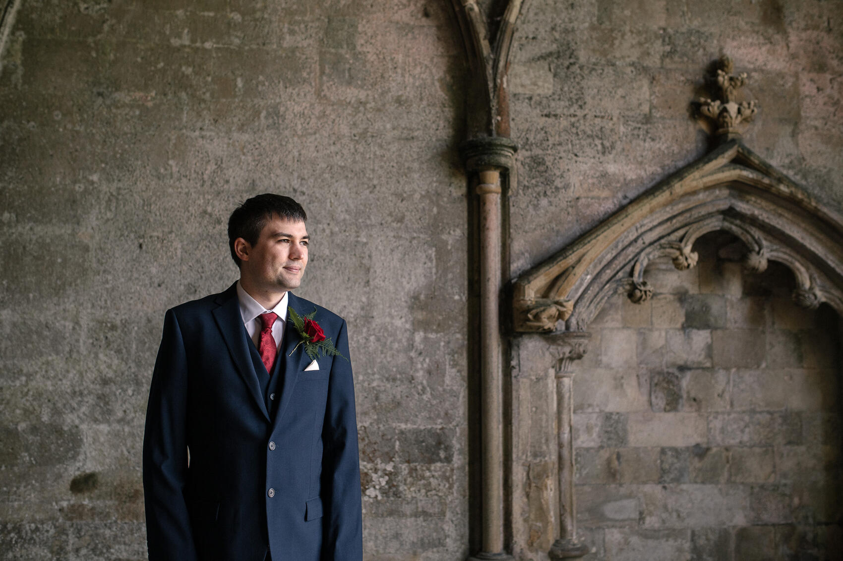 Groom waiting for the bride in doorway of Christchurch Priory wedding ceremony