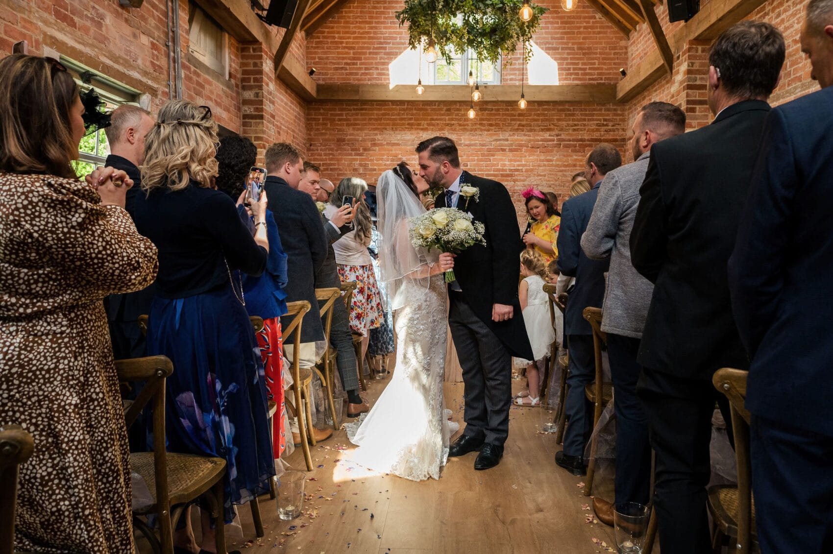 Couple stop for a kiss at Abbots Court wedding barn