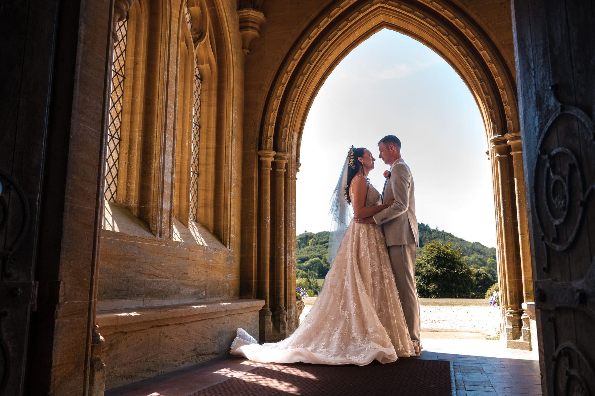 Bride and Groom kiss in the entrance to Milton Abbey Church