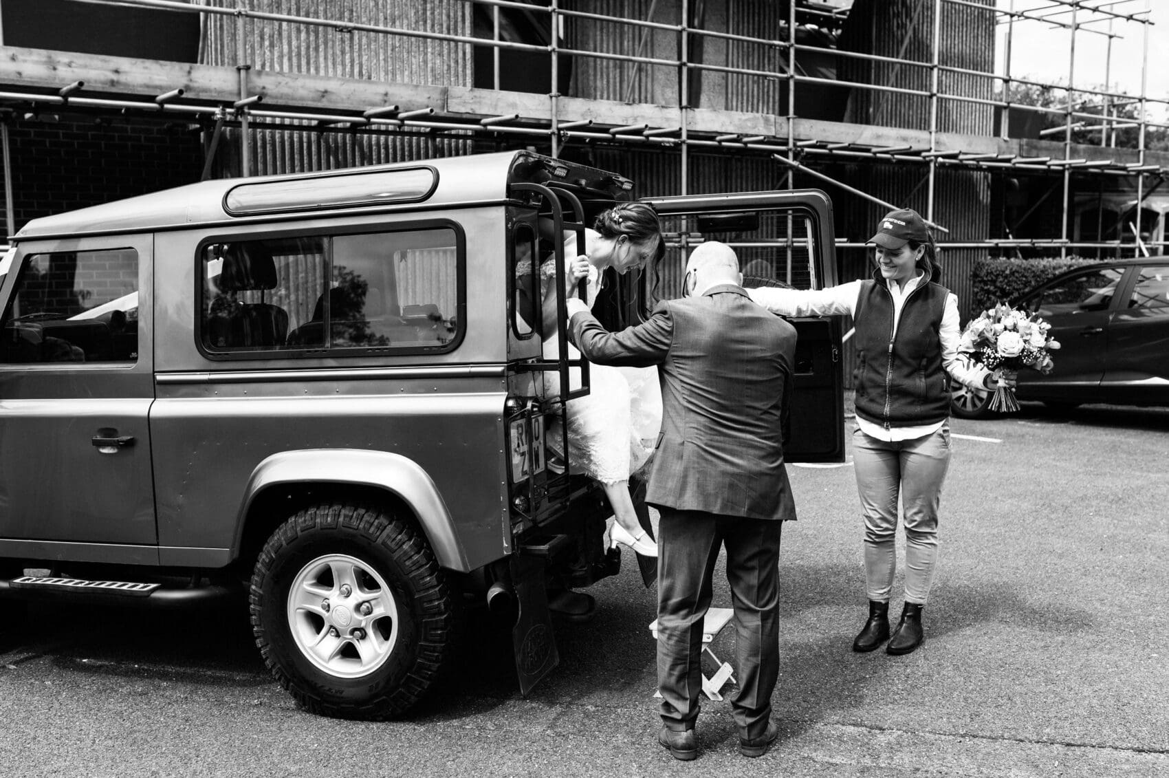 Bride exiting a Land Rover Defender at St Mary's Catholic Church wedding