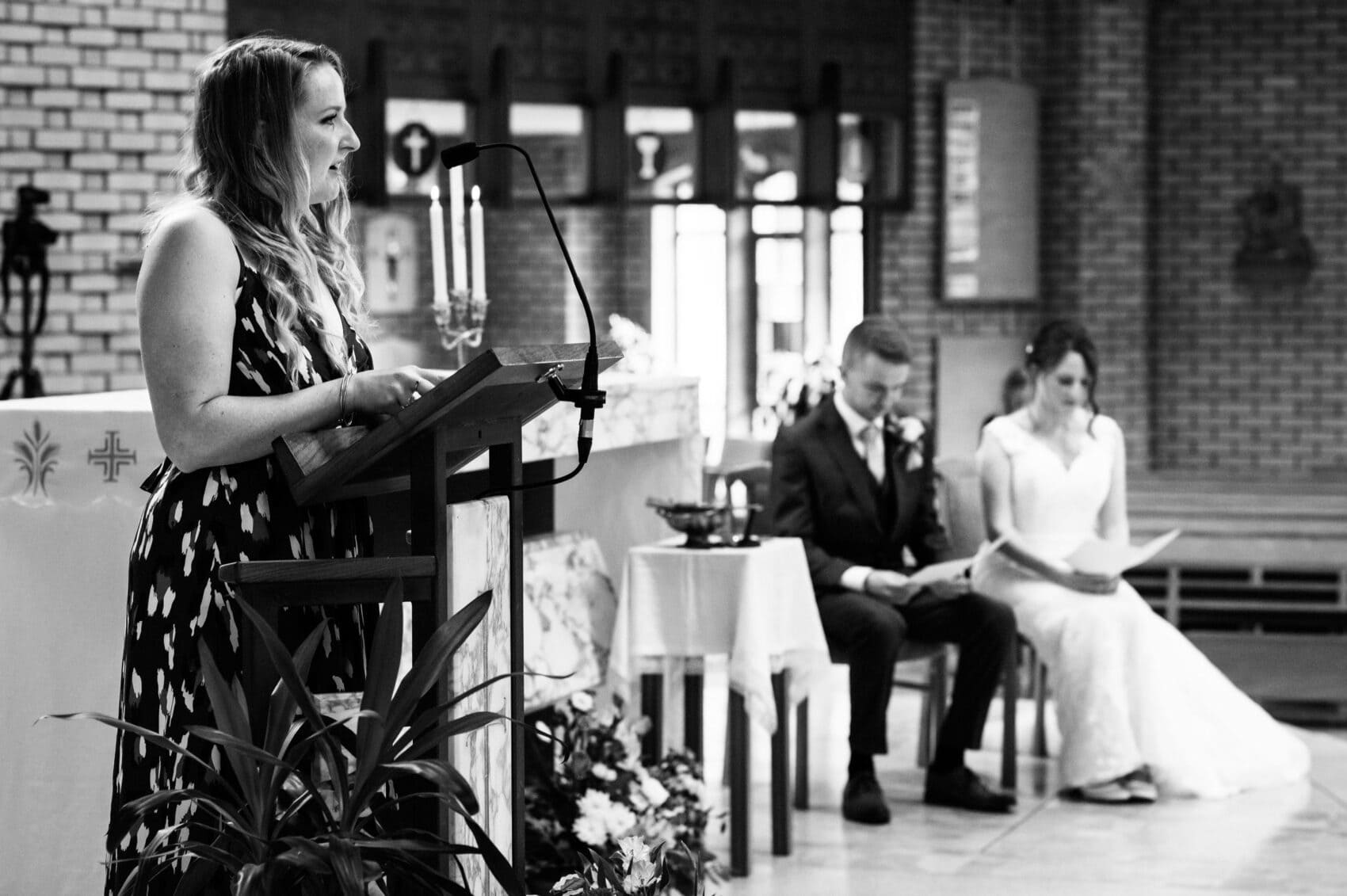 Bride and groom listen to a reading at St Mary's Catholic Church wedding