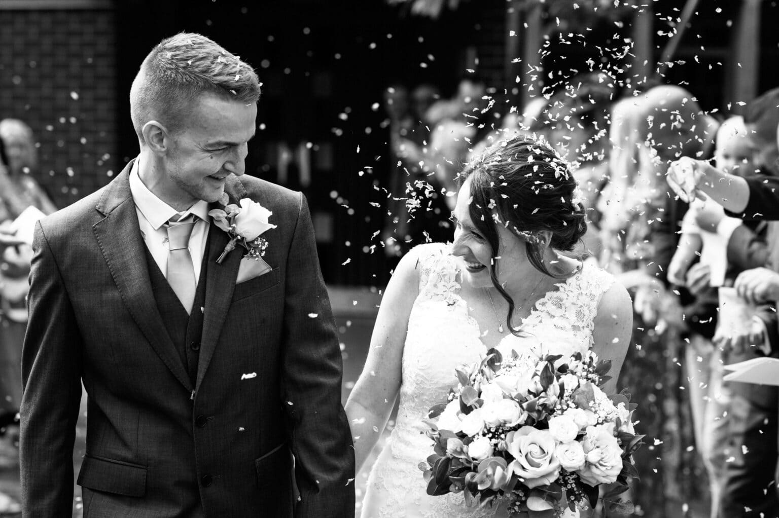 The bride, Megan takes a face full of confetti at St Mary's Catholic Church