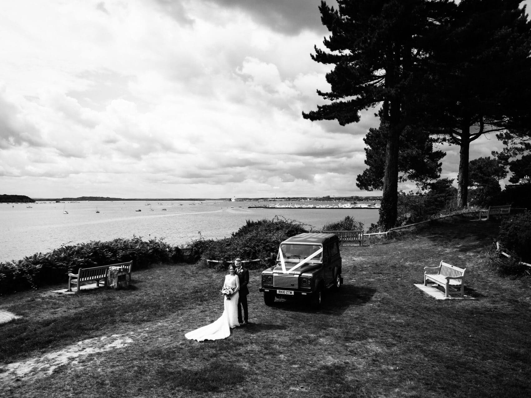 Bride and Groom with Land Rover Defender overlooking Poole Harbour