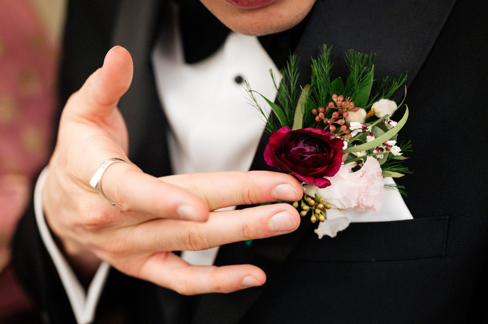 groom adjusts buttonhole