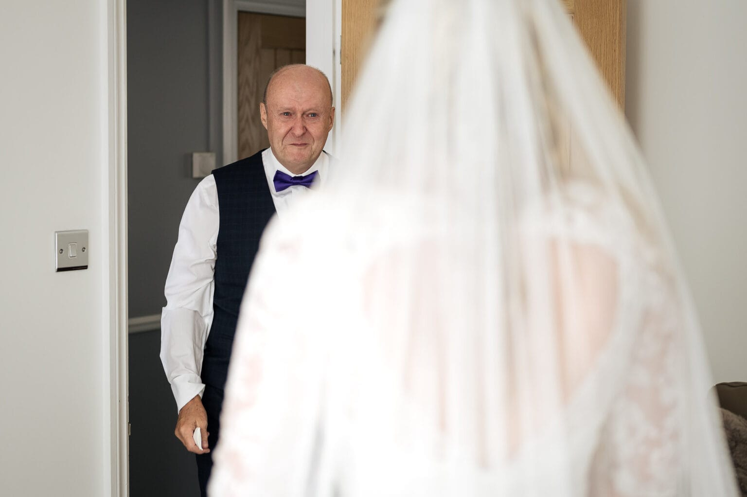 Father of the bride sees his daughter in her dress for the first time.