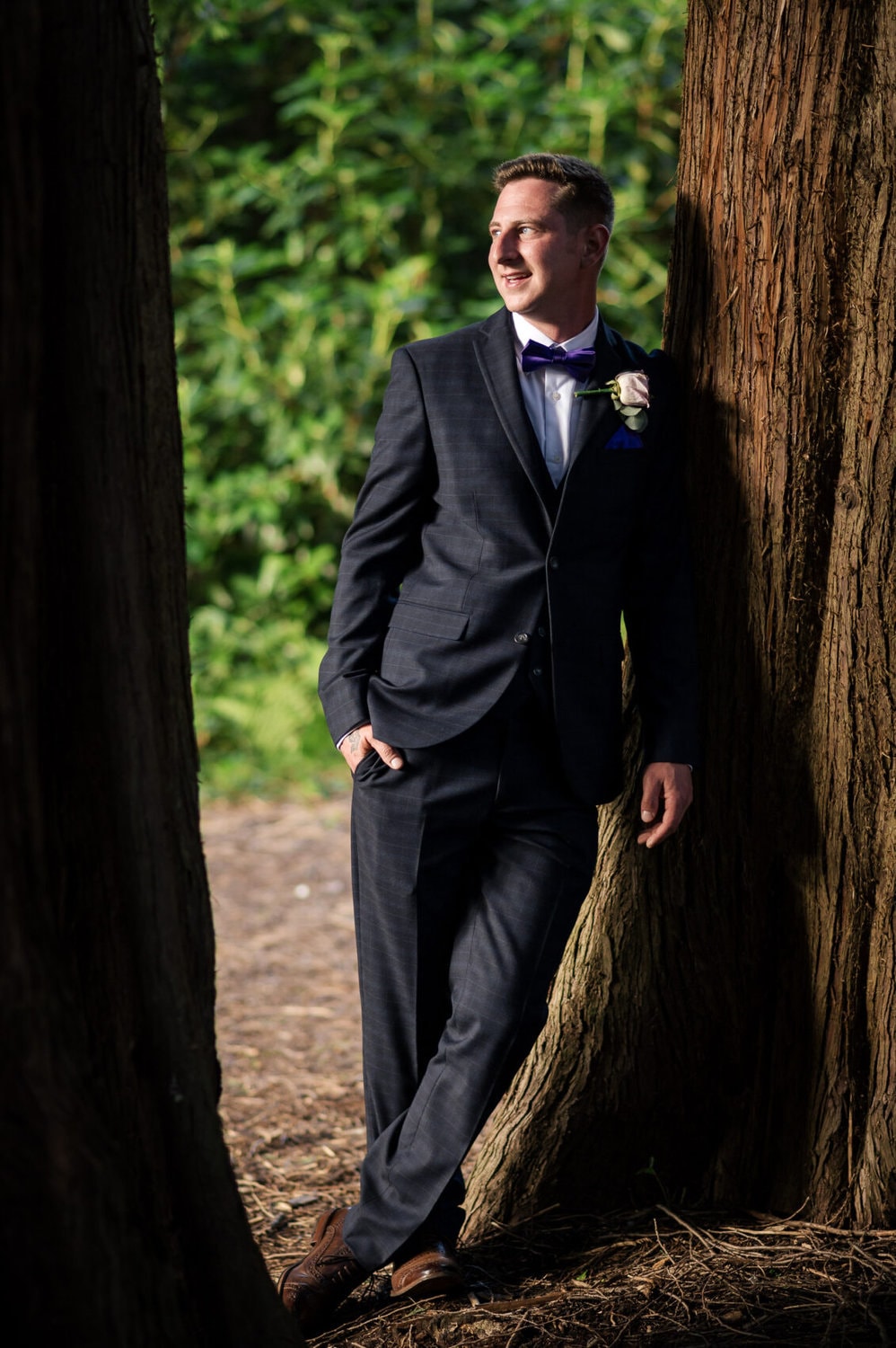 Groom leans on tree at Chilworth Manor Hotel wedding