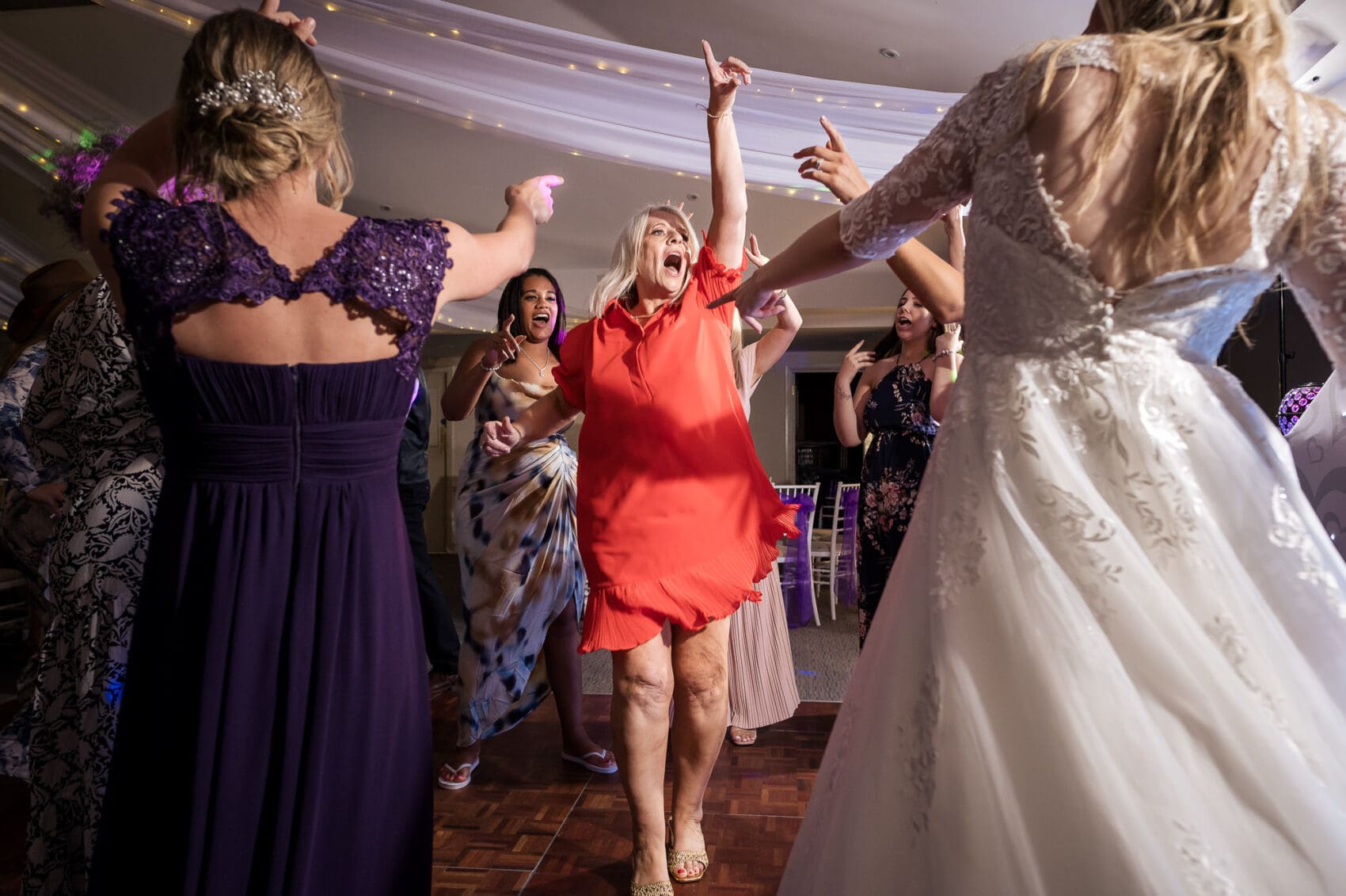 Mother of the Groom dancing in red dress. WPJA award winning photo