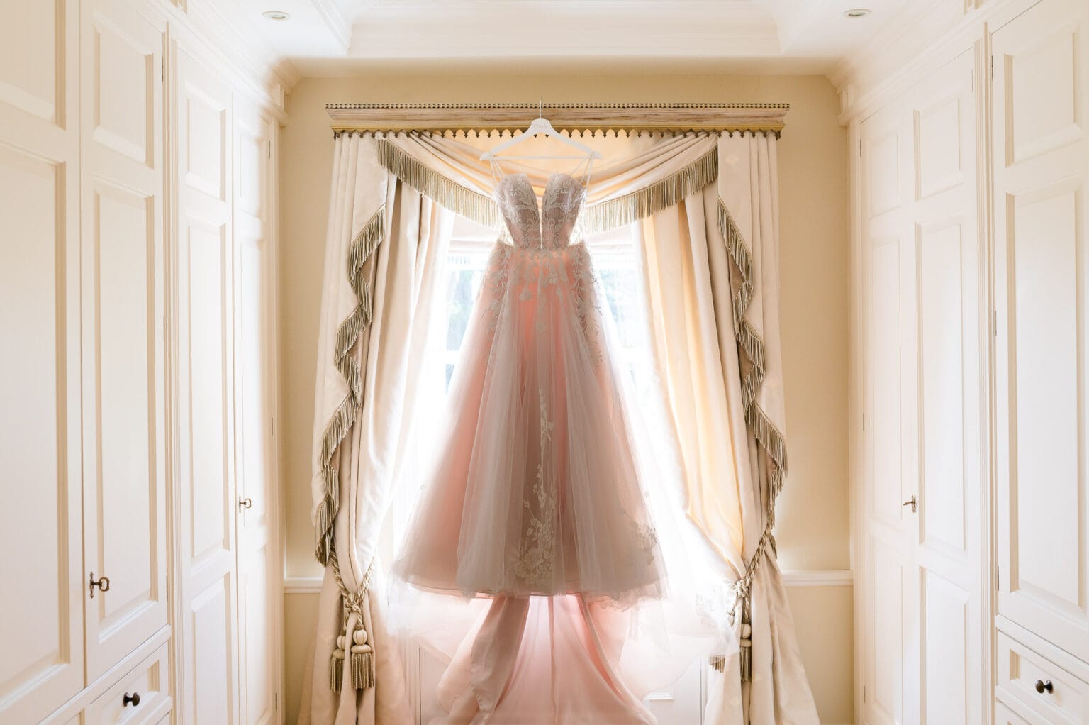 Wedding dress hanging in window at Hethfelton House wedding