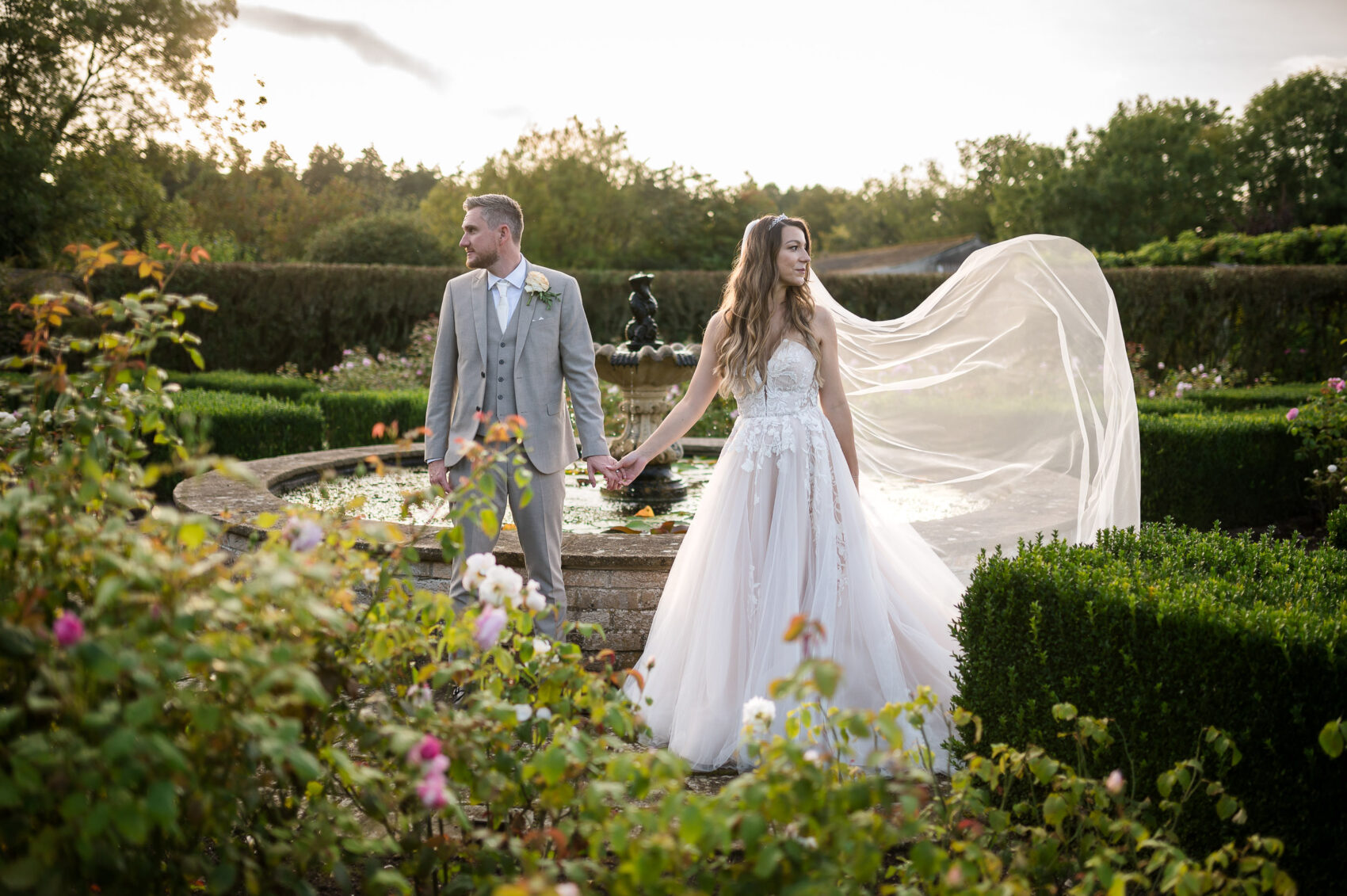 Bride and groom pose for formal photos in walled garden at Hethfelton House wedding