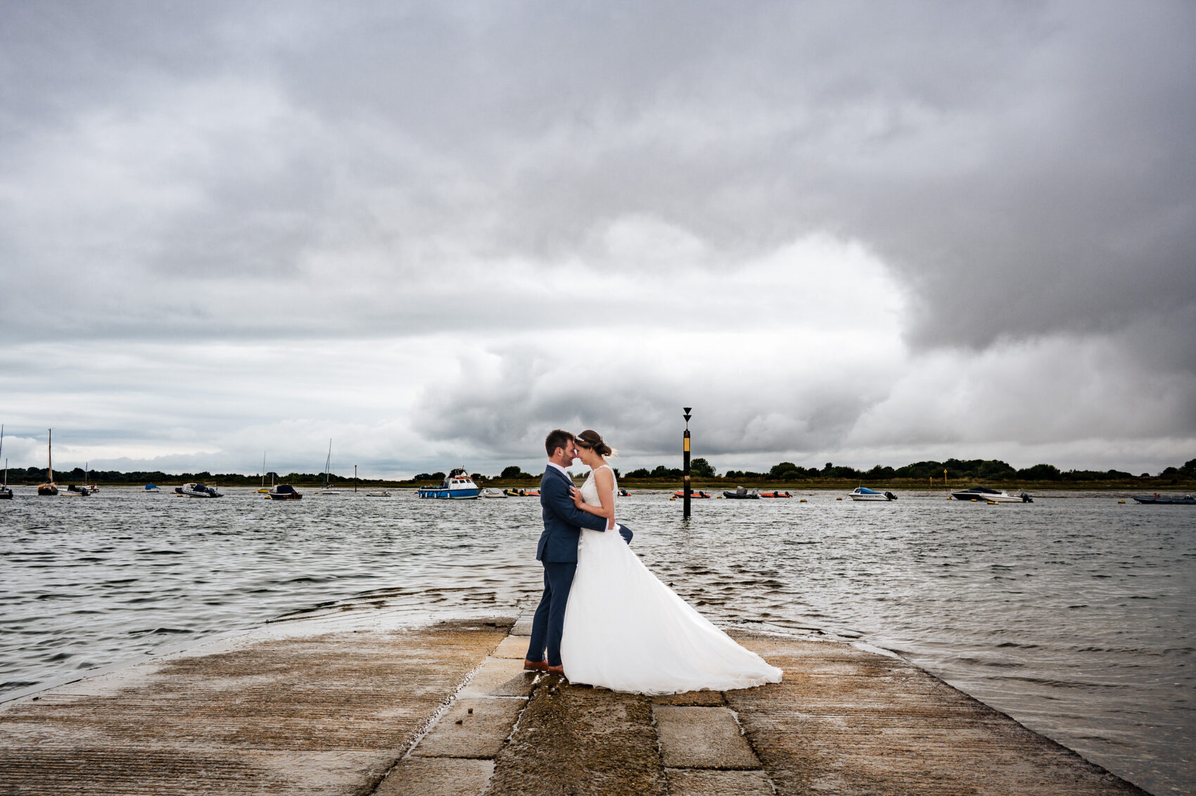 bride and groom on the Slipway with storm clouds behind