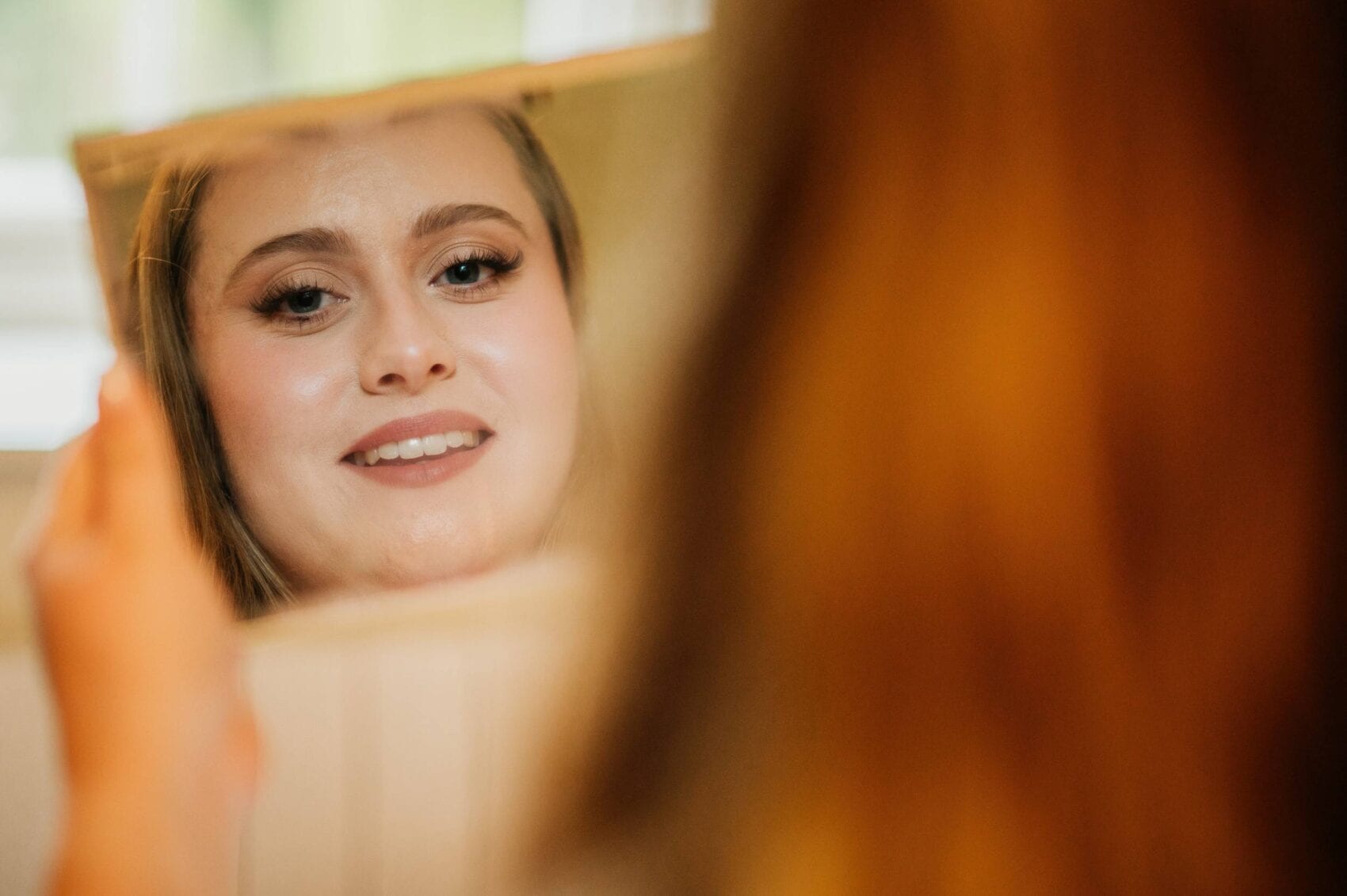 Bride looks in the mirror at Hale Park House Wedding