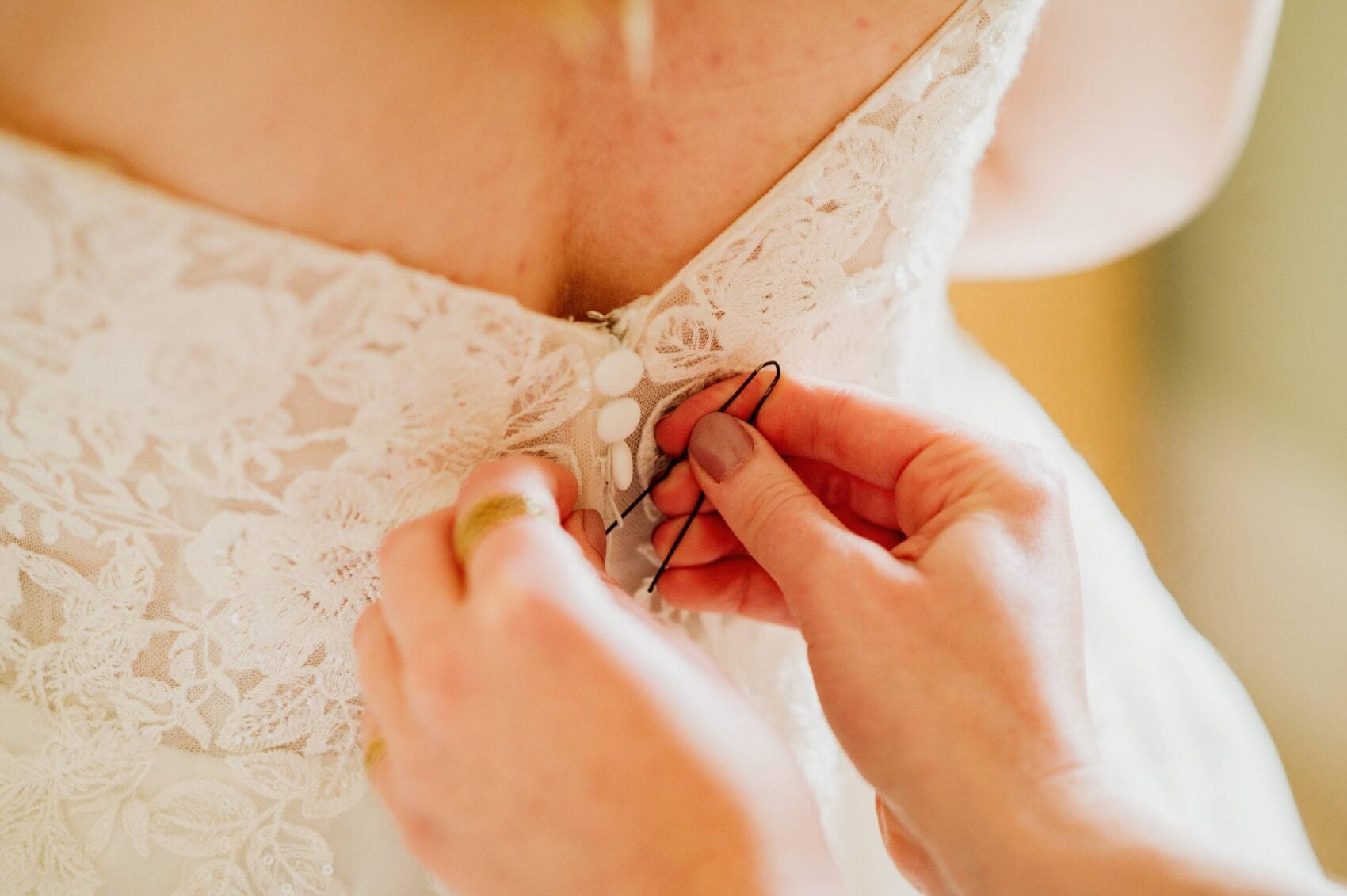 doing up the dress at Hale Park House Wedding