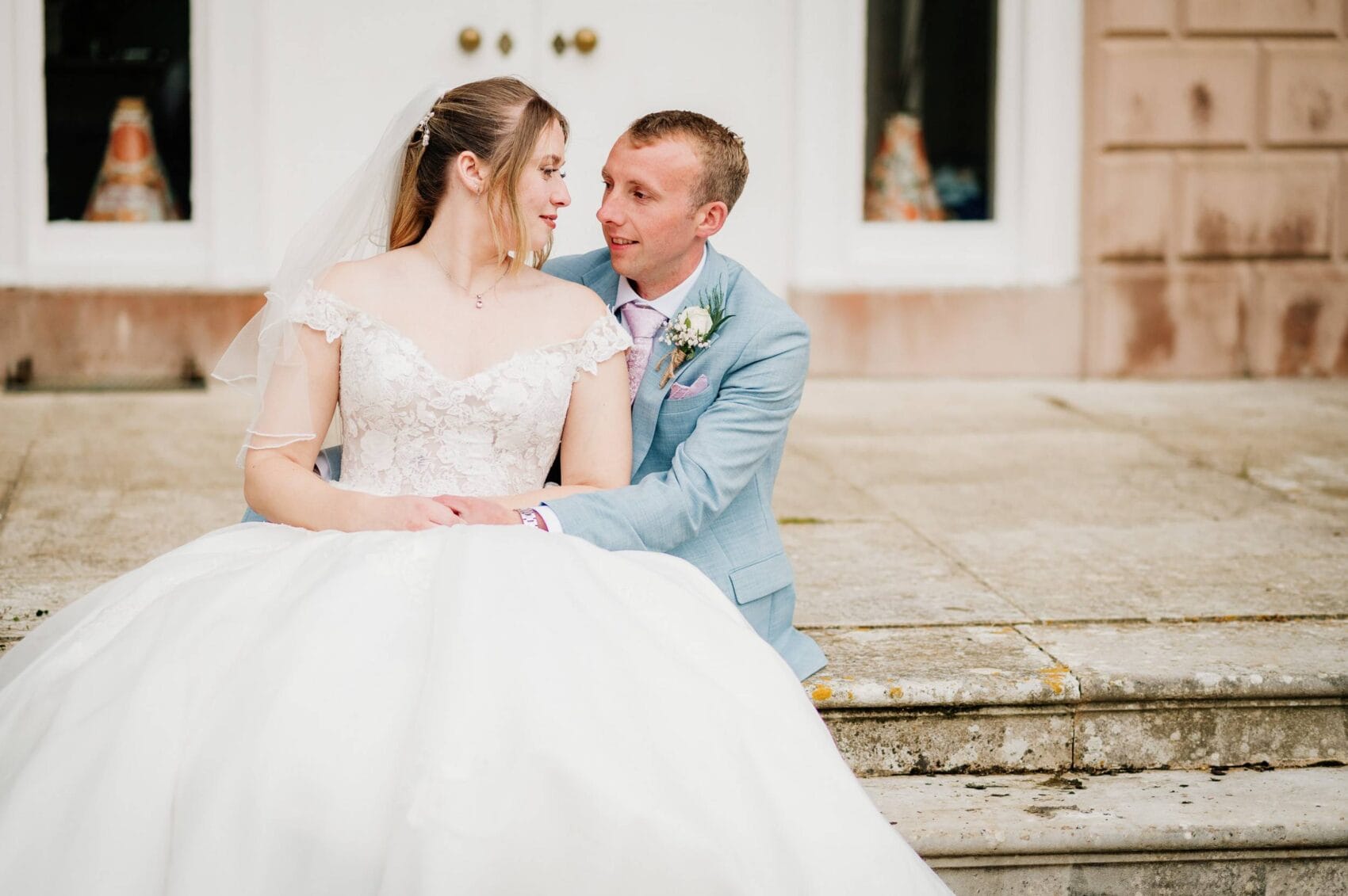 bride and groom on the steps of hale park house