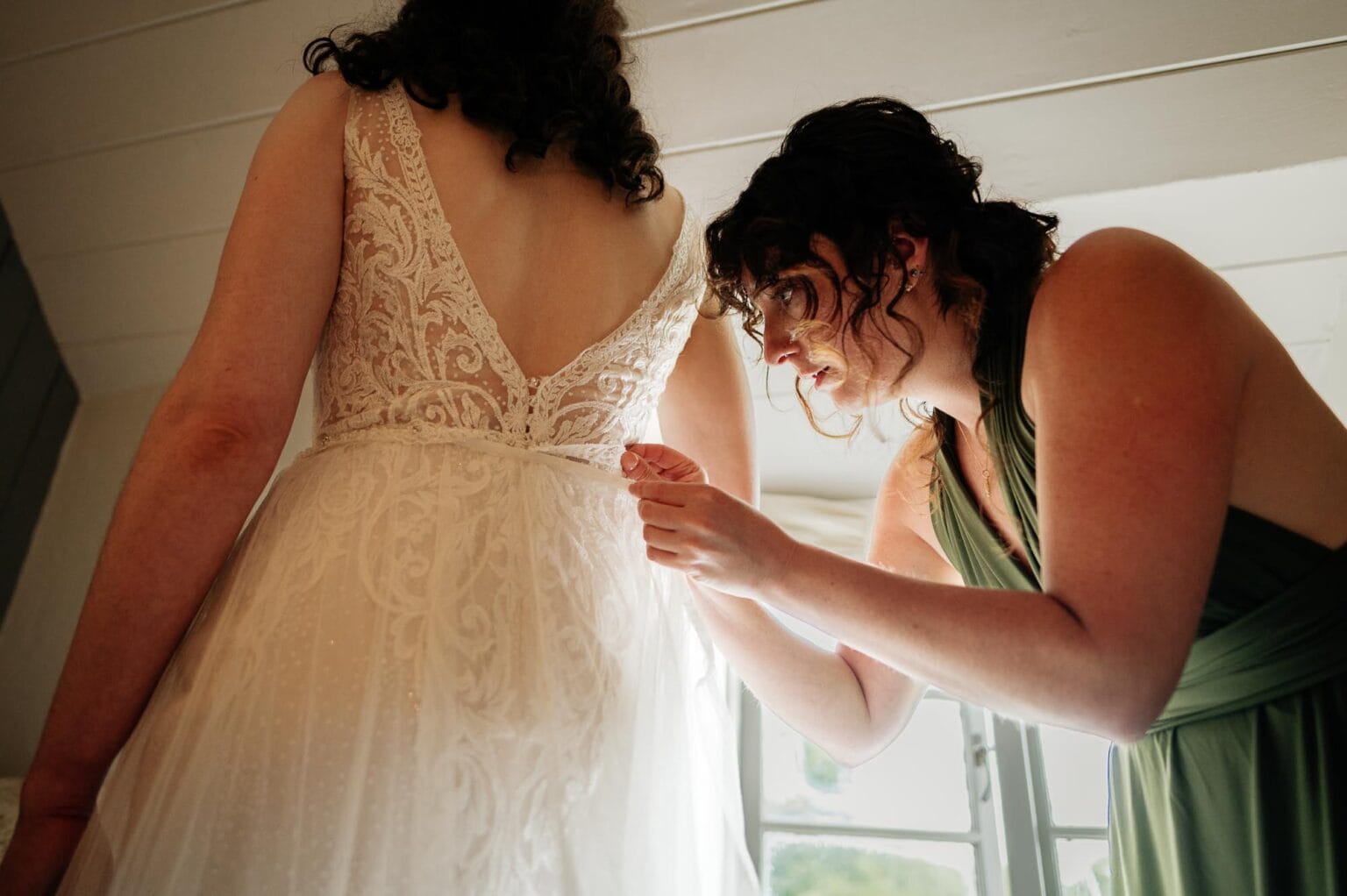 Bridesmaid fastening dress at River Cottage wedding