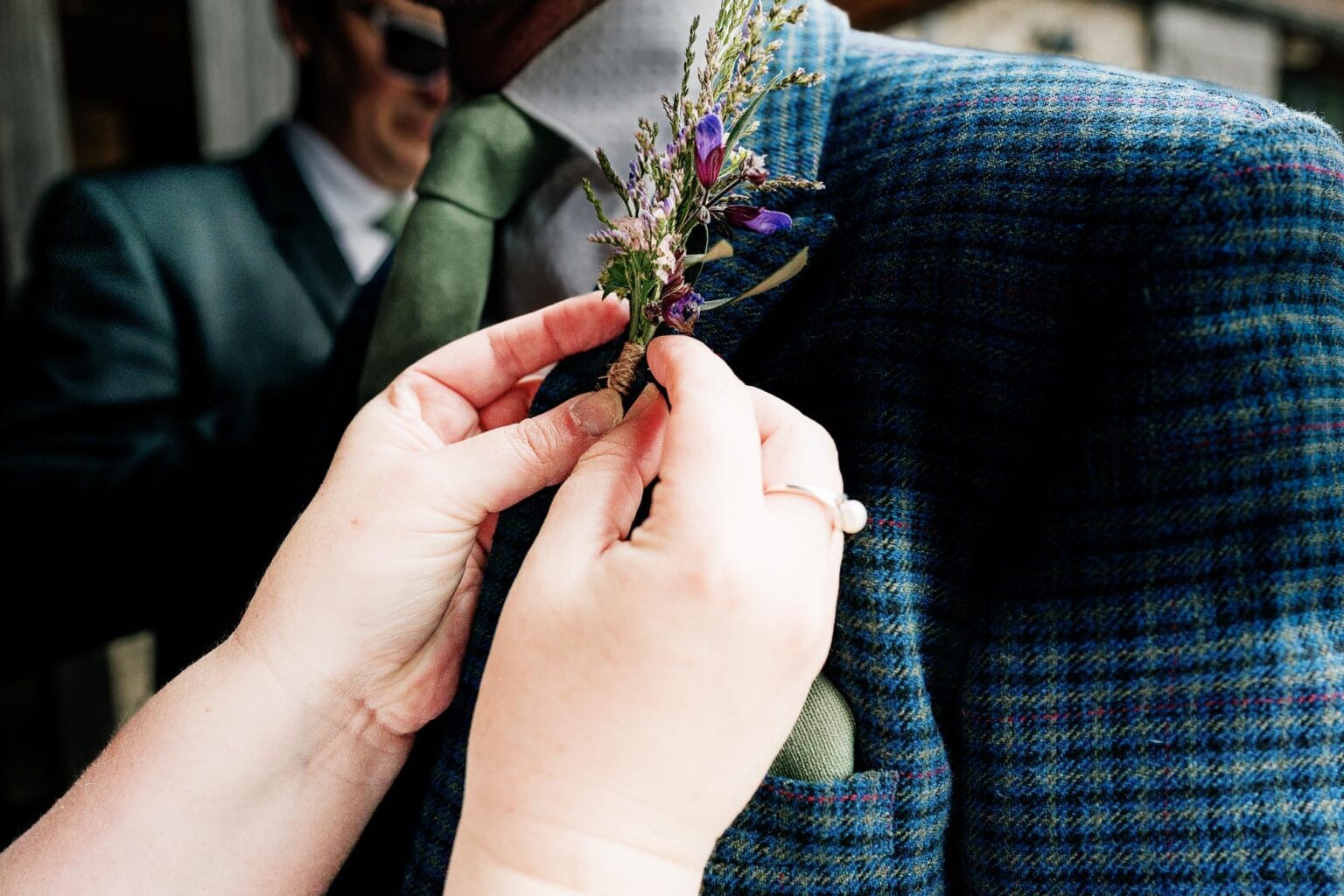 Buttonhole flower being fixed to the lapel of a suit