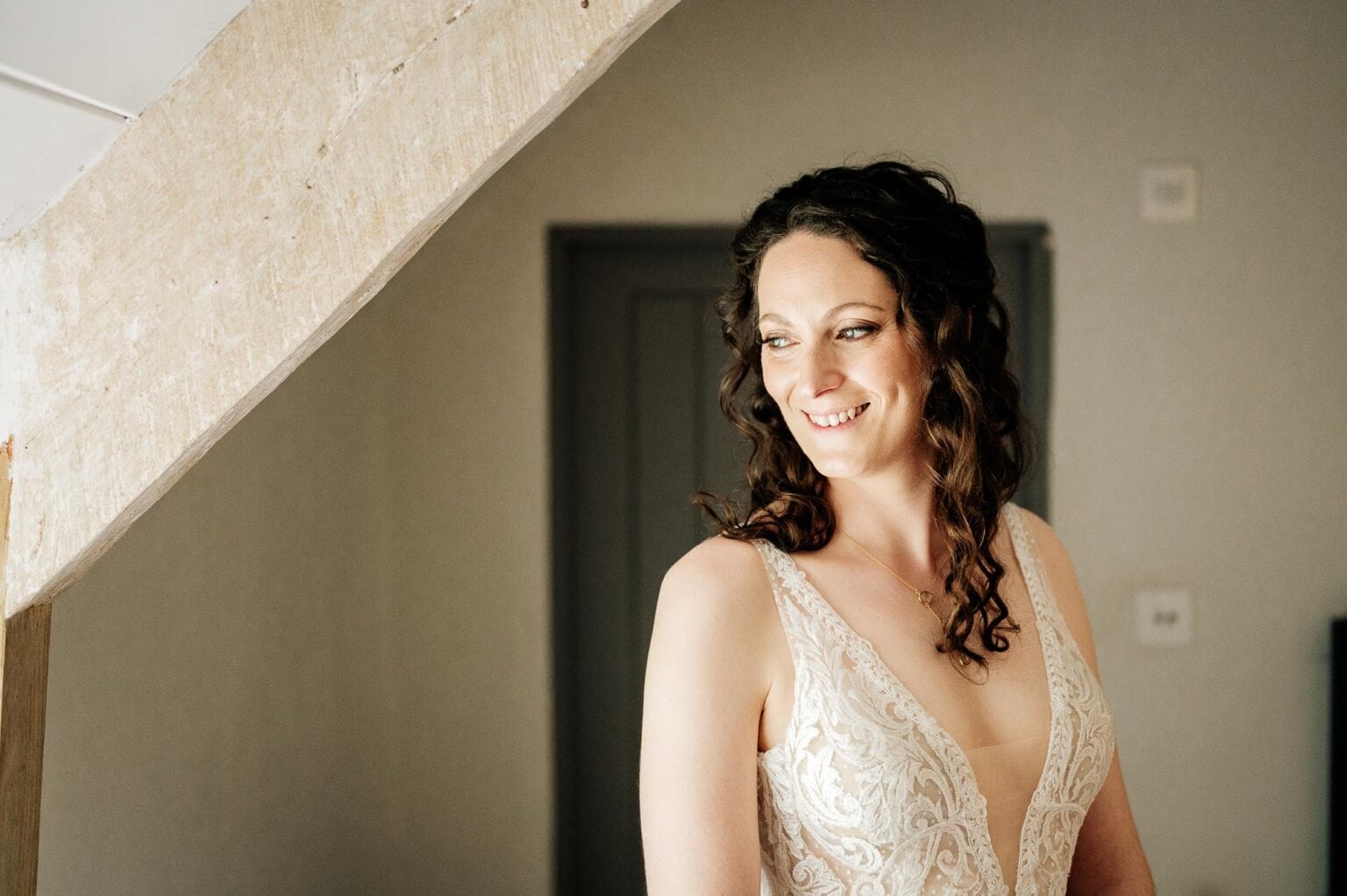 Bride smiling in windowlight at River Cottage wedding