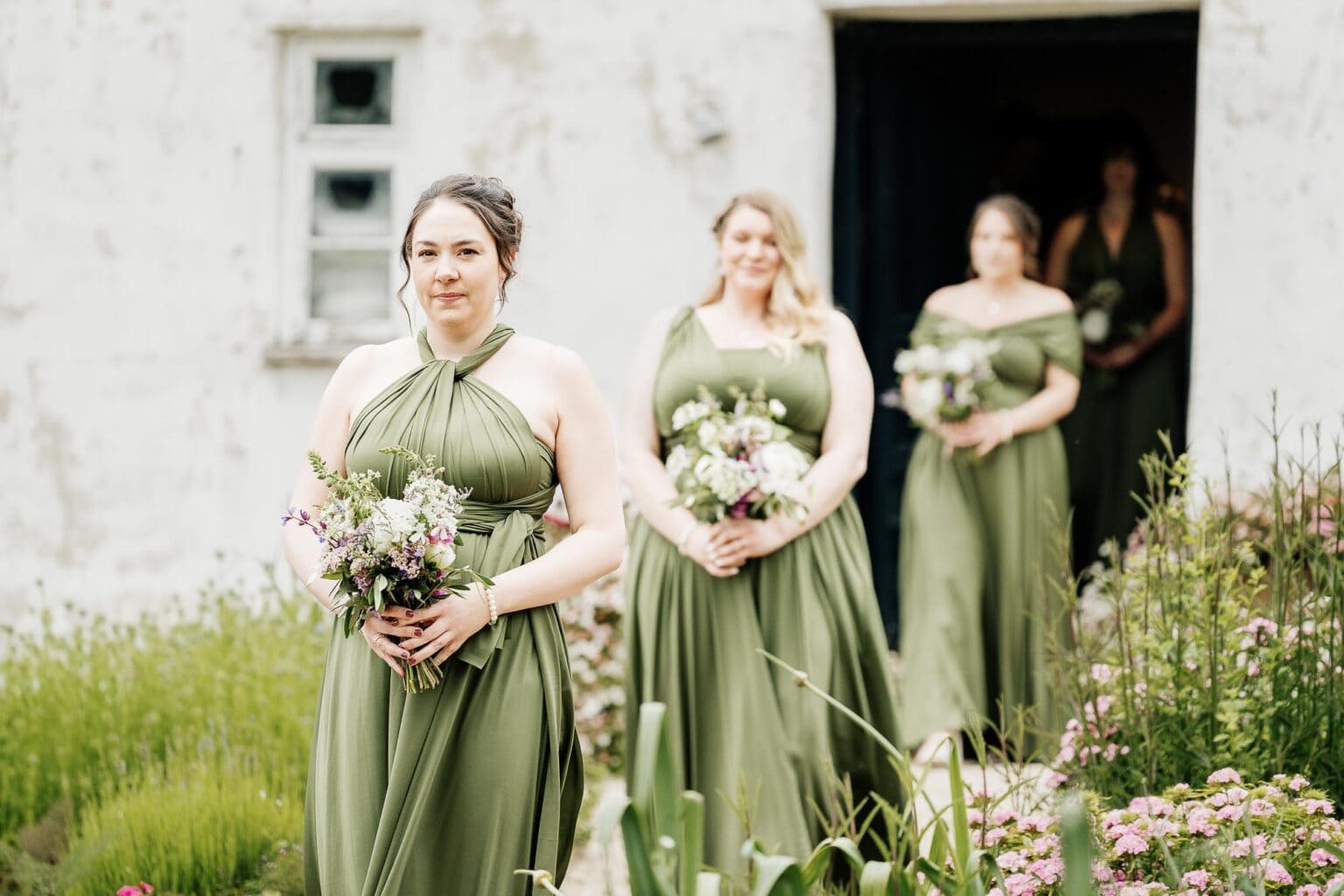 River Cottage wedding photographer watches the bridal party walk through the garden