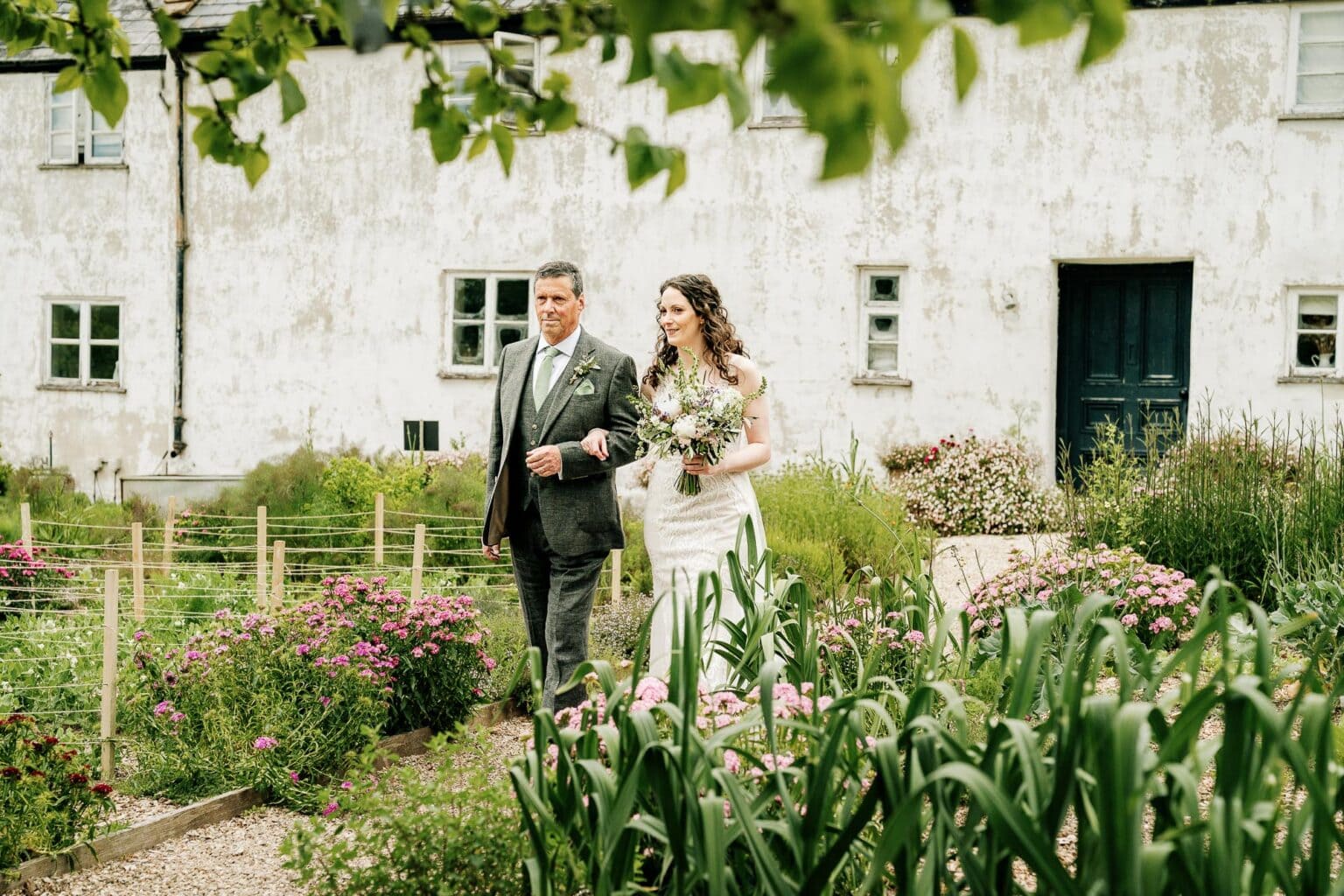 Dad walks his daughter to the wedding in the kitchen garden at River Cottage wedding