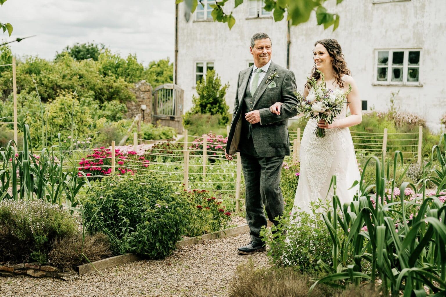 a quick smile from dad as they get to the aisle in the kitchen garden at River Cottage wedding