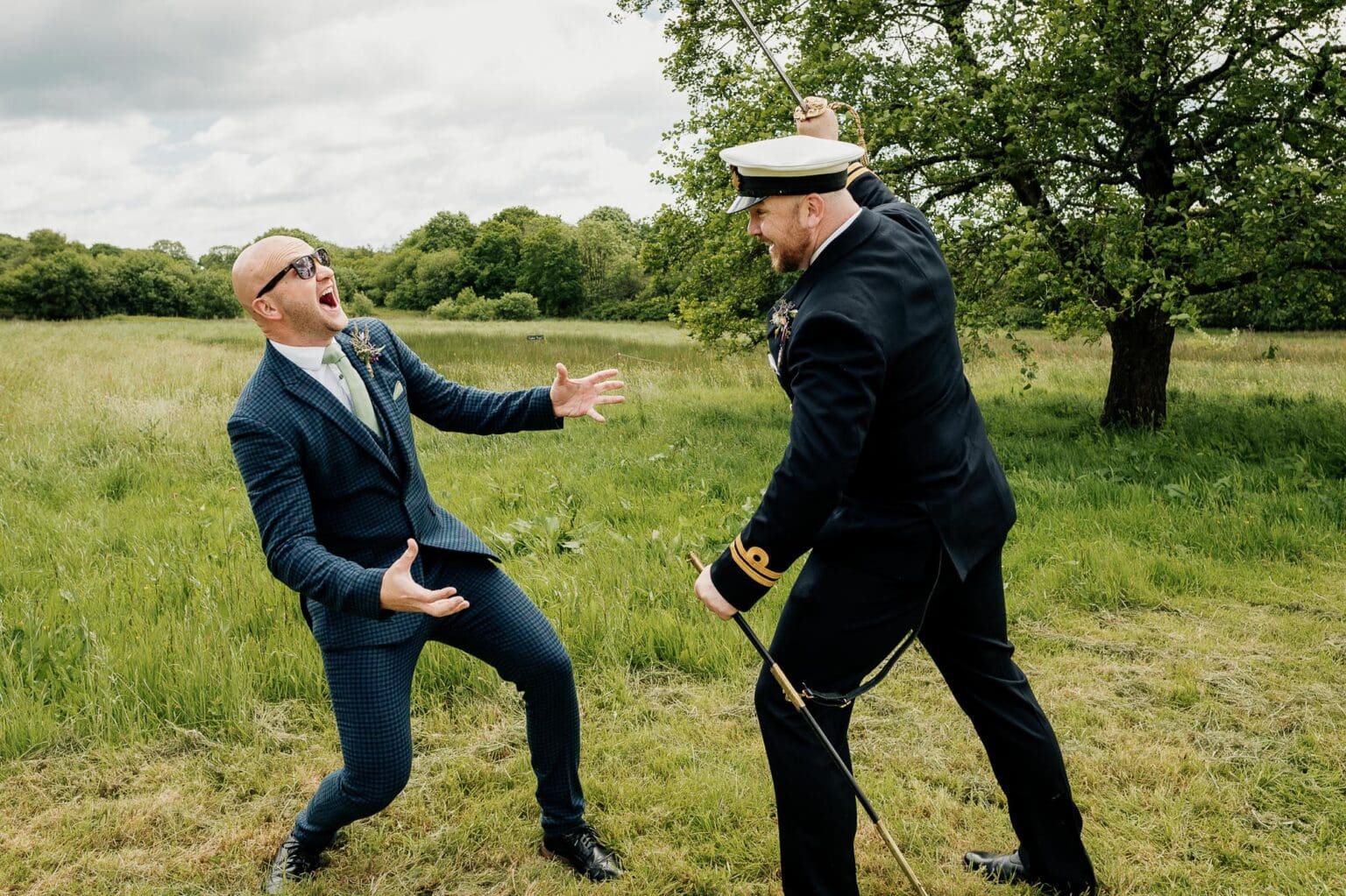 groom pretends to cut his brother with sword at River Cottage garden wedding