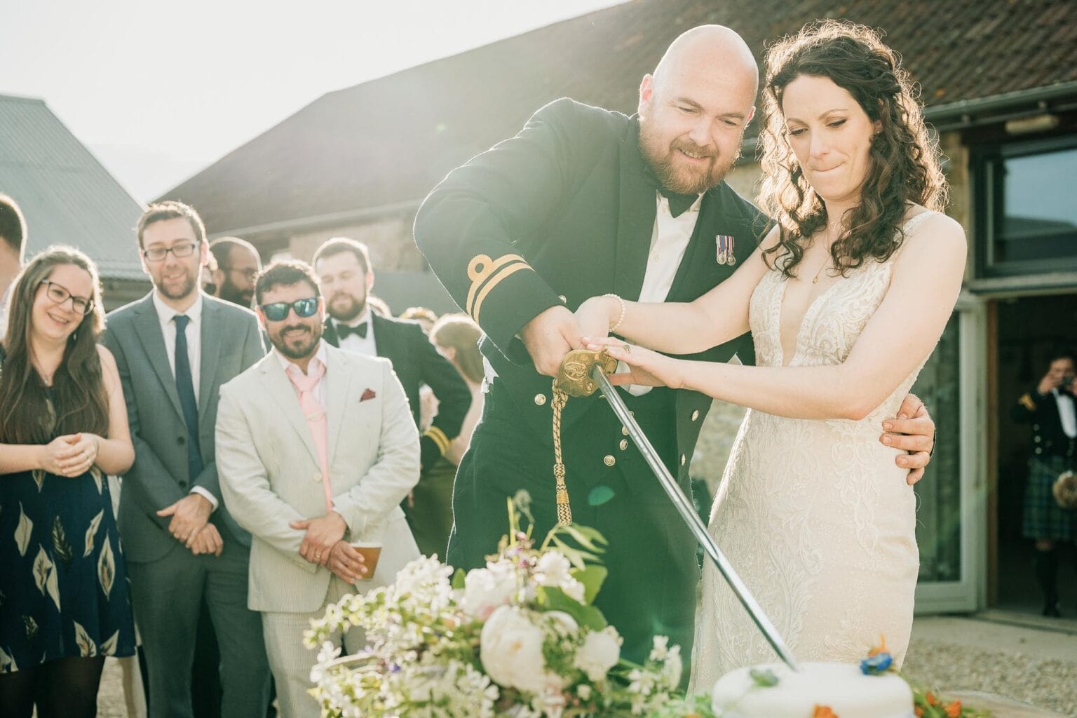 Cutting the cake in the courtyard of River cottage HQ wedding