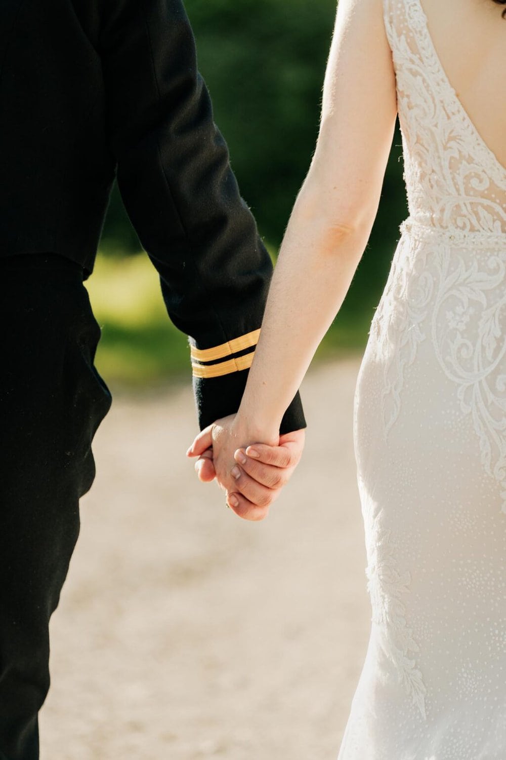 close up of the bride and groom holding hands