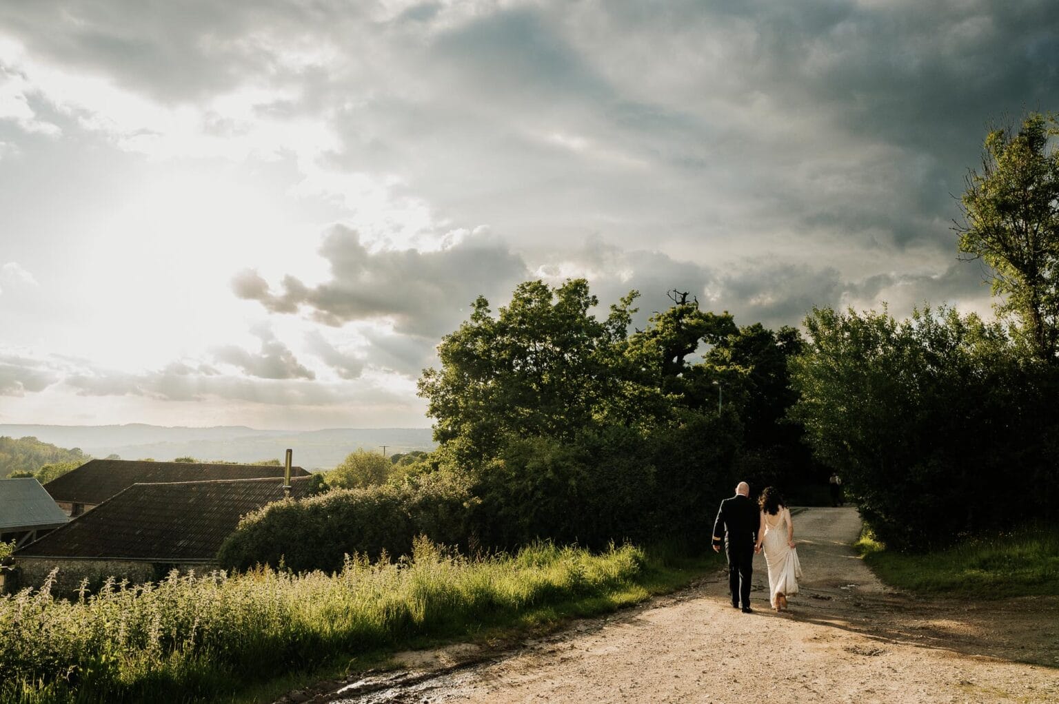 River cottage wedding sunset with the bride and groom wandering off into the shadows