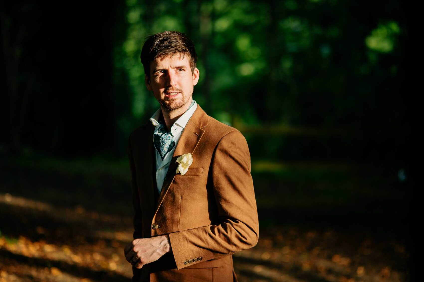 Groom poses in the evening ligh at Owlpen Manor weddding