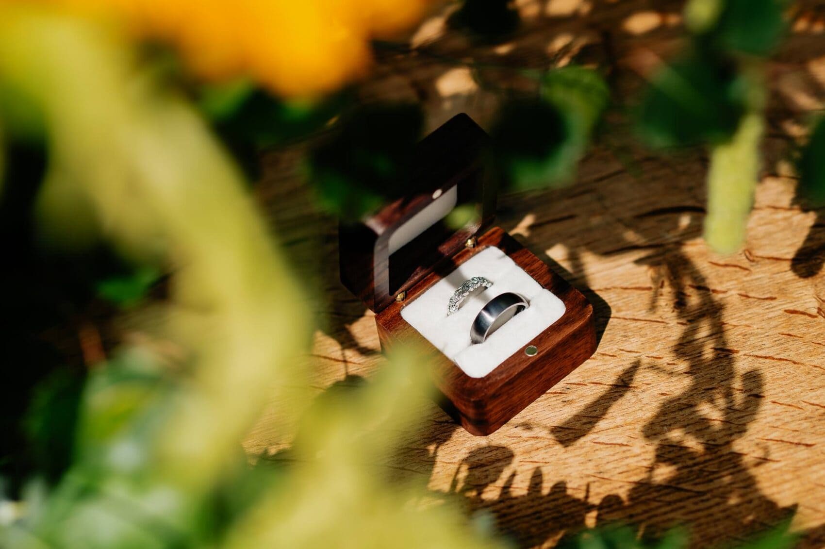 Owlpen Manor weddding rings on the table surrounded by flowers and shadows