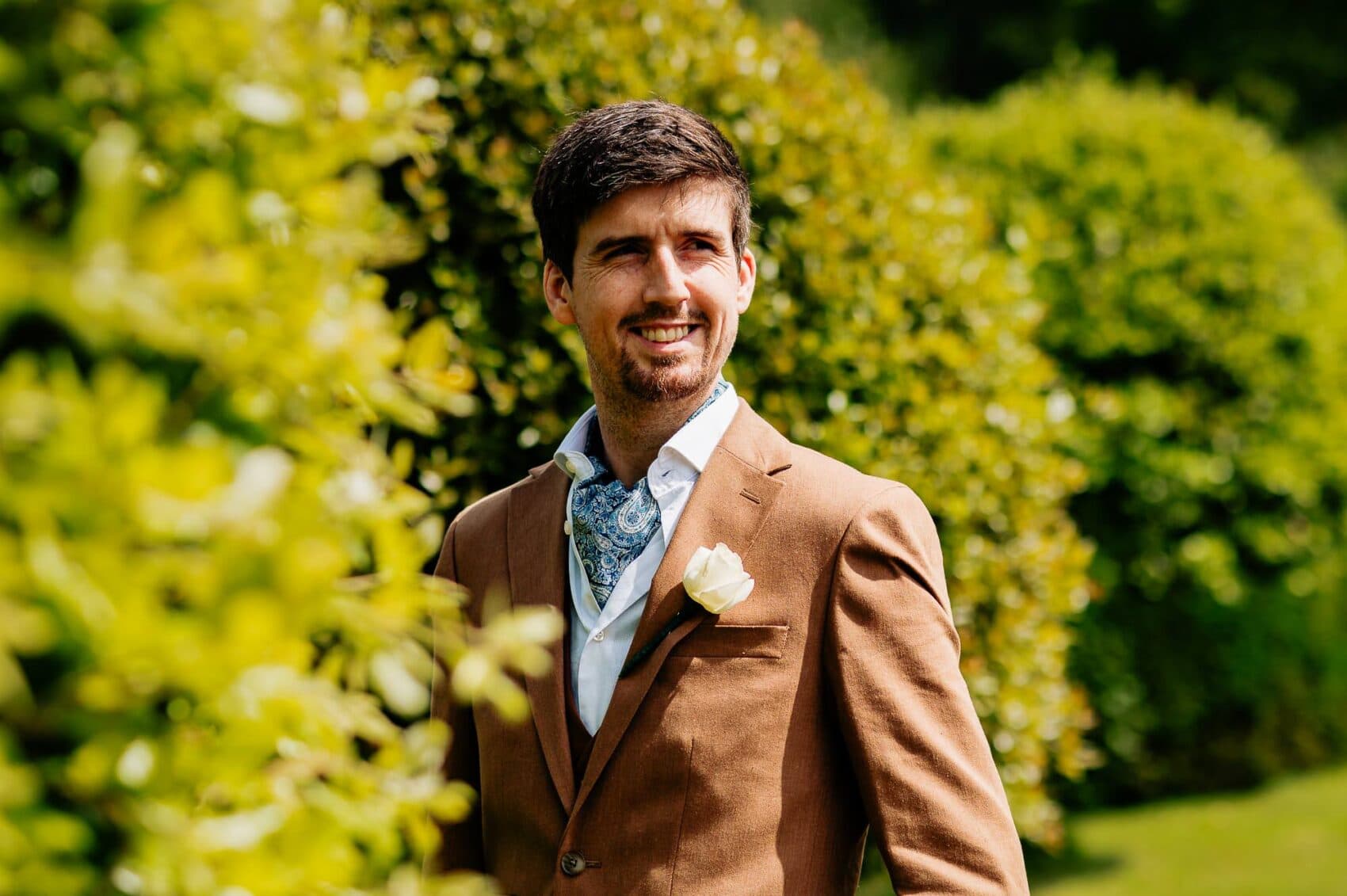 The Groom waits on the lawn for his bride at Owlpen Manor weddding