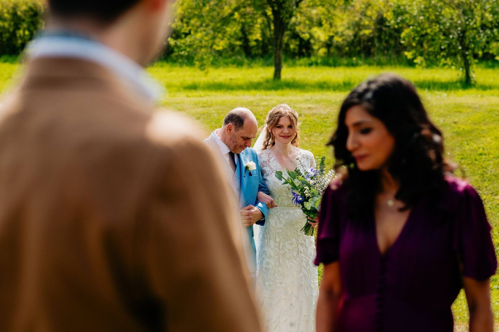 Bride turns the corner at the end of the aisle to see her groom at Owlpen Manor weddding