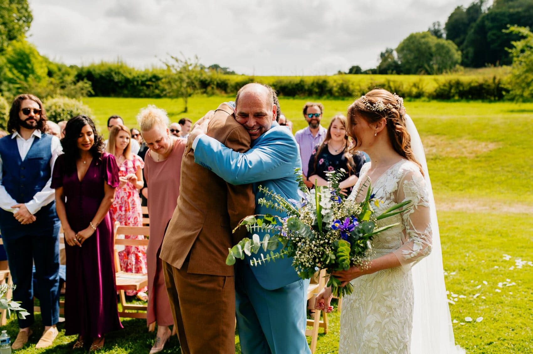 Dad hugs the groom at Owlpen Manor weddding ceremony