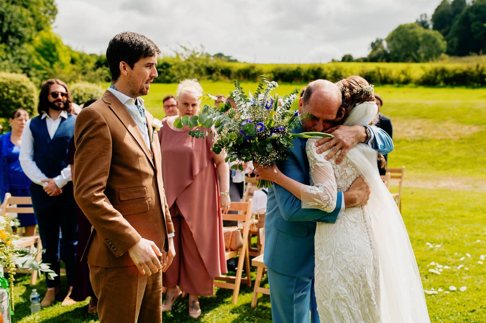 Dad gives his daughter an emotional hug as he gives her away at Owlpen Manor outdoor weddding