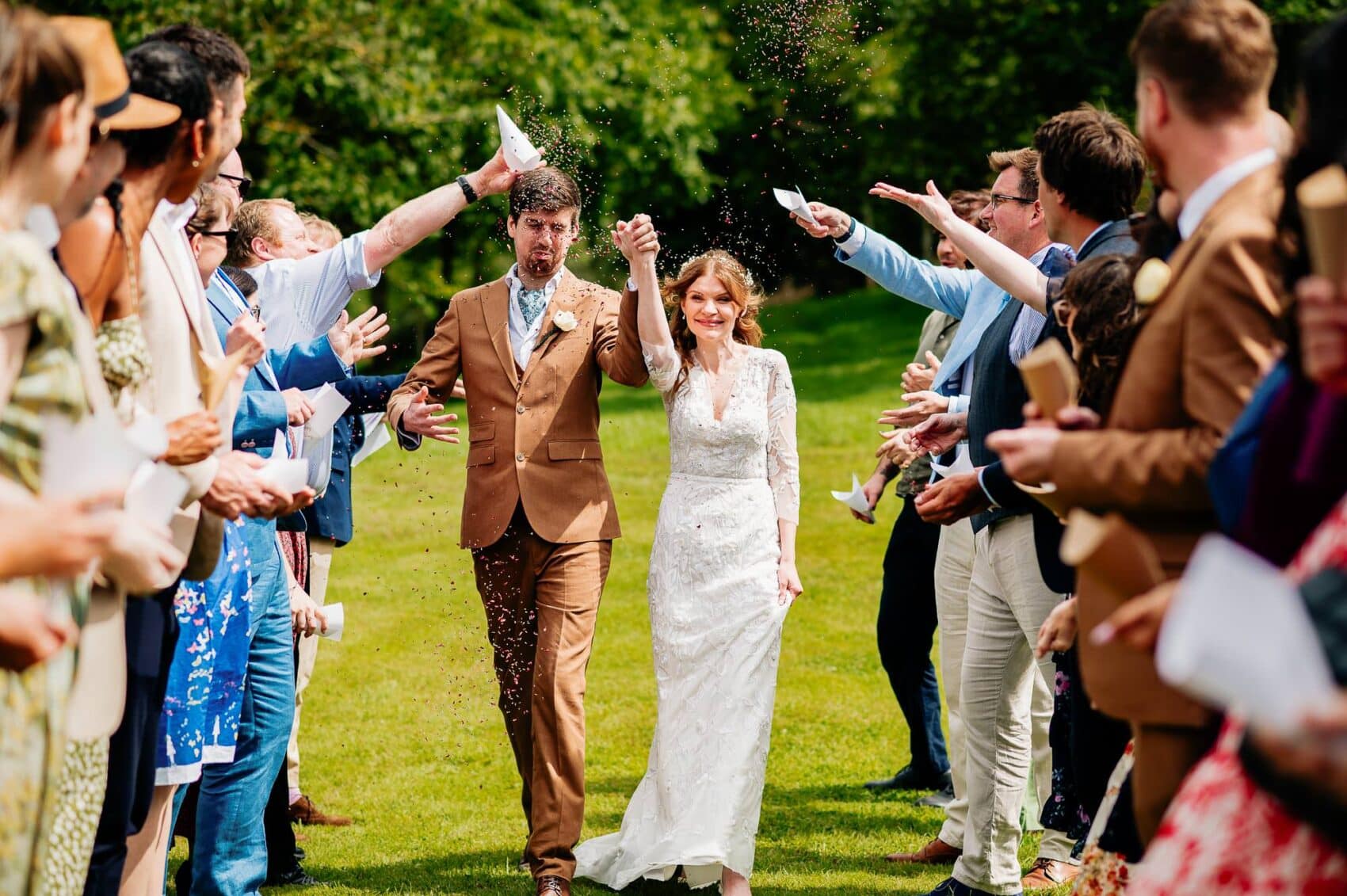 Confetti being thrown on the bride and groom at Owlpen Manor weddding