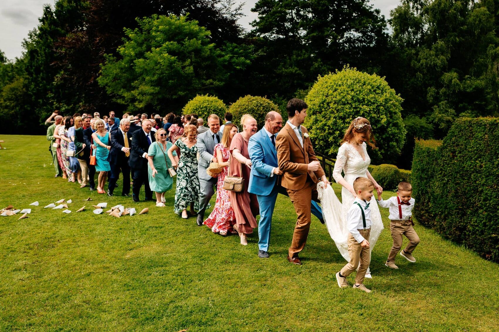 Exiting the ceremony with a Conga line at Owlpen Manor weddding