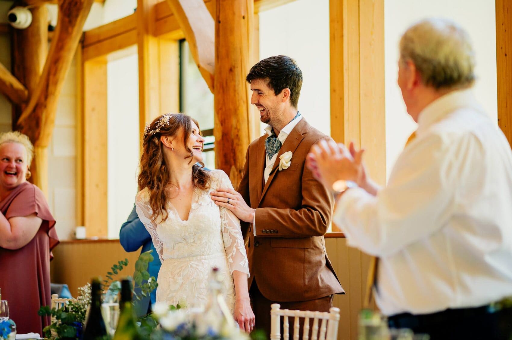 Bride laughing with the groom as she sits at Owlpen Manor weddding