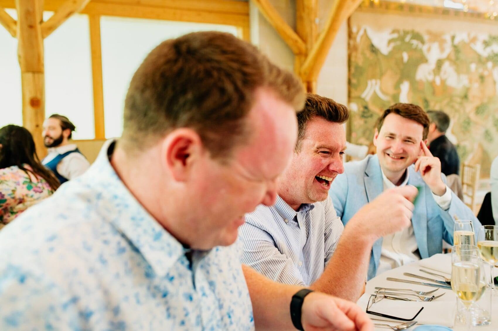 Three guests laughing hard at Owlpen Manor weddding