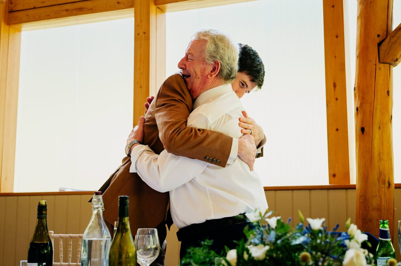 Father and son hug after the wedding speeches