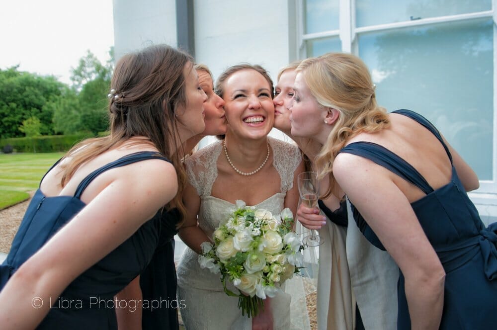 Bridsmaids kiss the bride